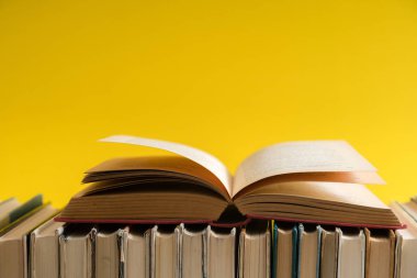 Sarı arka planlı, ahşap masa ciltli kitap açık kitap. Eğitim ve arka plan öğrenme. Okul için okuyor. Metin için yer kopyalayın