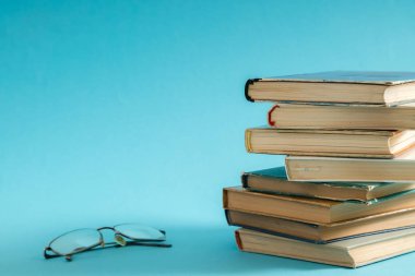 Açık kitap, ikincisini sert kapak okuma gözlüğü tarafında ile renkli kitaplar. Okula dönüş. Metin için yer kopyalayın. Eğitim, eğitim, öğrenme, iş kavramı