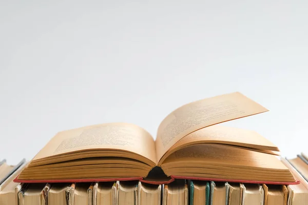 Beyaz arka plan üzerine açık bir kitap, ahşap masa üzerine sert ciltli kitaplar. Eğitim ve öğrenim geçmişi. Okula dönüyorum, ders çalışıyorum. Metin için alanı kopyala