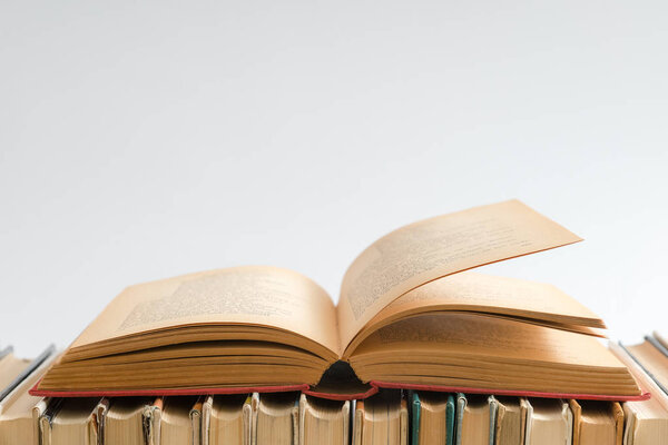 Open book on white background, hardback books on wooden table. Education and learning background. Back to school, studying. Copy space for text