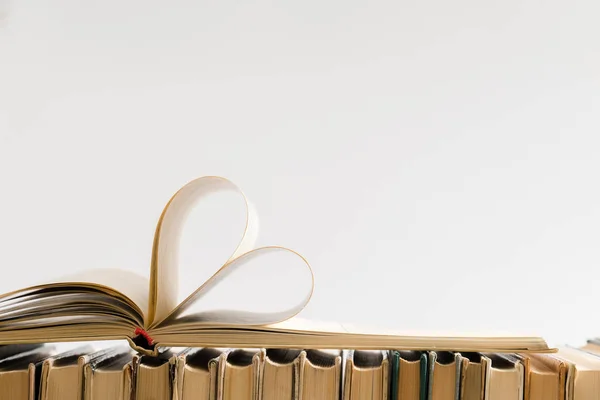背景をぼかした写真とビンテージ スタイルのバレンタインの日に愛をハート形に古いハードカバーの本のページを飾る 学校の構成 — ストック写真
