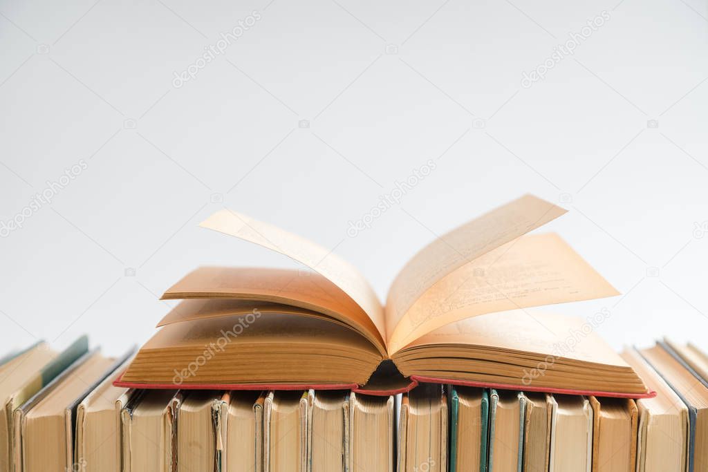 Open book on white background, hardback books on wooden table. Education and learning background. Back to school, studying. Copy space for text