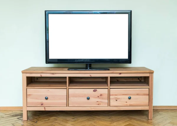 Flat LCD television on brown wooden cabinet in the living room with a white screen for copy text