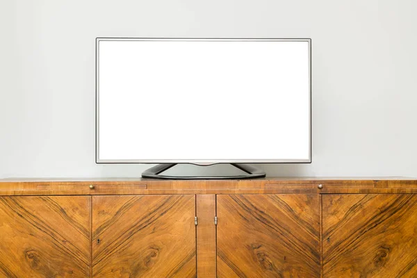 Flat LCD television on brown wooden cabinet in the living room with a white screen for copy text