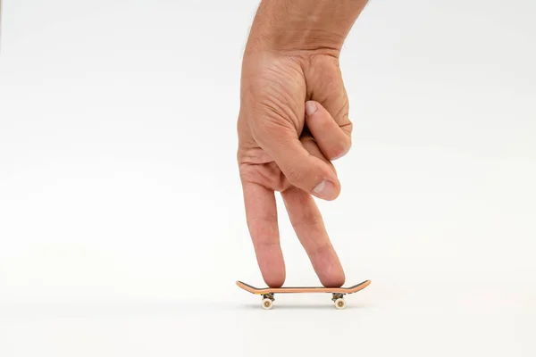 Toets. Een kleine skateboard voor kinderen en tieners om te spelen met de vingers van de hand. Geïsoleerd op witte achtergrond — Stockfoto