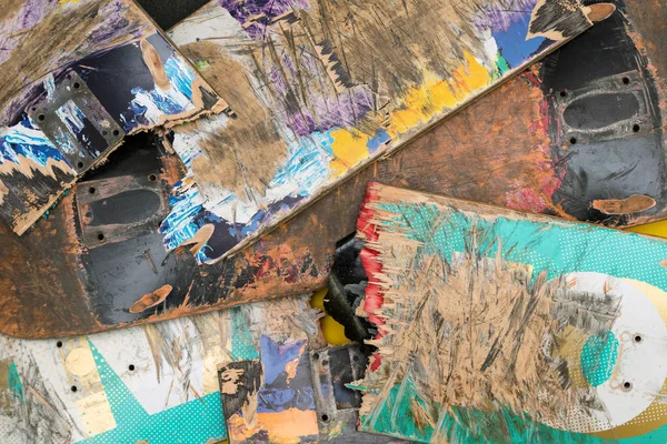 Broken colourful skateboard decks stacked on top of each other, skateboard recycling