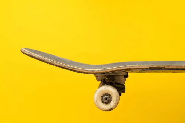 Профессиональный скейтборд на желтом фоне вид сбоку, палуба, полная настройка, грузовик, палуба, колеса — стоковое фото