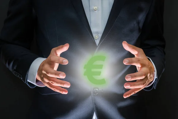 Controlling money concept. Currency symbol - euro sign between human hands. Money making and wealth
