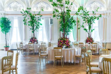 Düğün masa dekorasyonu. Güzel tabak, kristal bardak ve tabaklar yanındaki masaya çiçek buketi