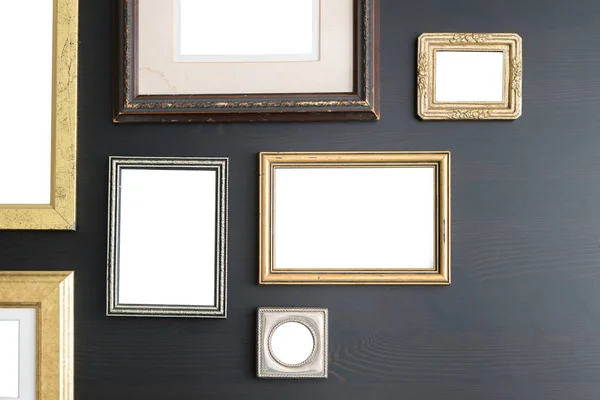 Blank empty frames on dark wooden background. Art gallery, museum exhibition white clipping path