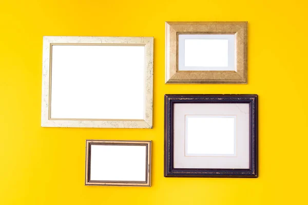 Blank empty golden, wooden frames on yellow background. Art gallery, museum exhibition white clipping path