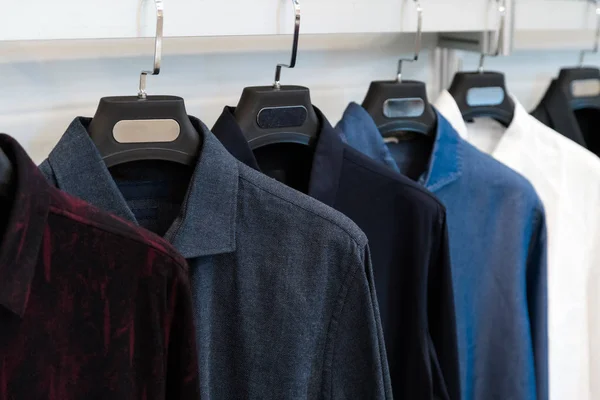 Designer shirts on display in a retail store. Different colour and texture shirts hanging on a hanger