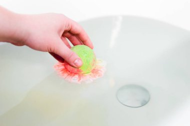 Yeşil ve kırmızı kabarcıklanma top elinde banyo tuzları gibi. Bomba banyo için. Elinde erir