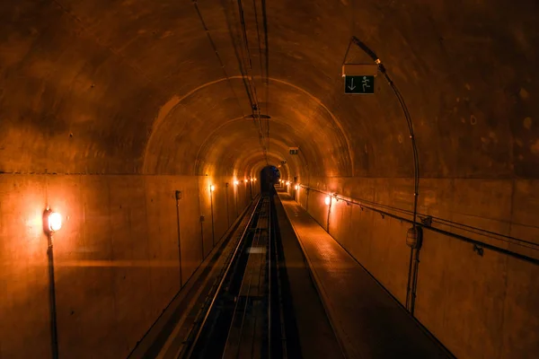 Narrow dark metro tunnel, railway perspective into darkness