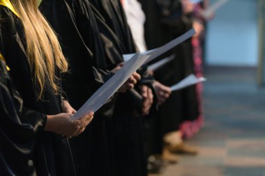 Müzikal puanı tutan ve öğrenci mezuniyet gününde Üniversitesi, üniversite diploması başlamasından şarkı Koro şarkıcıları