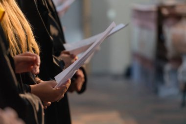 Müzikal puanı tutan ve öğrenci mezuniyet gününde Üniversitesi, üniversite diploması başlamasından şarkı Koro şarkıcıları