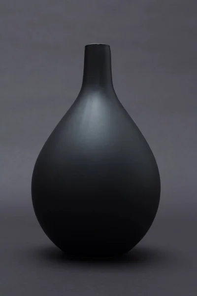 Matte black ceramic vase on black background isolated