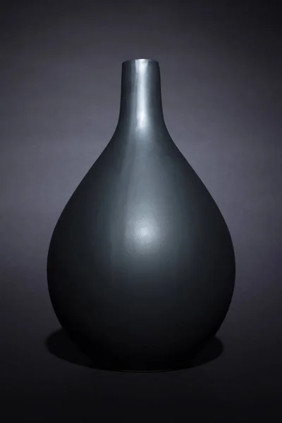 Matte black ceramic vase on black background isolated