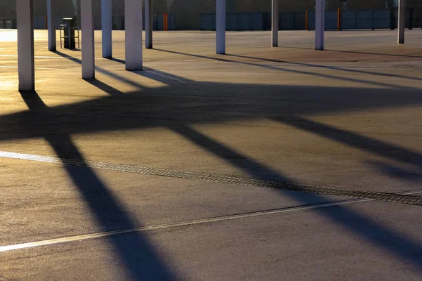 Modern architecture shadows on the ground back lit by warm evening sun. Sunset shadow