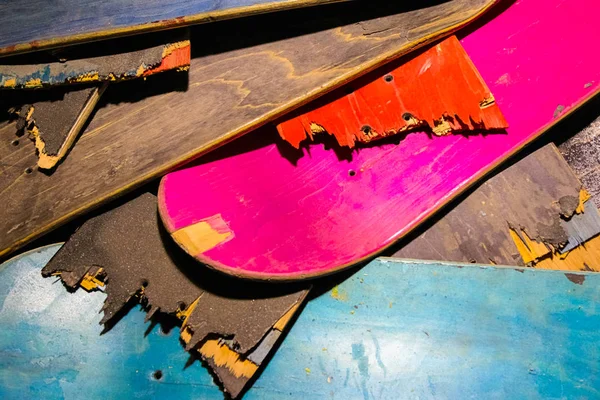 Broken colorful skateboard decks stacked on top of each other, skateboard recycling