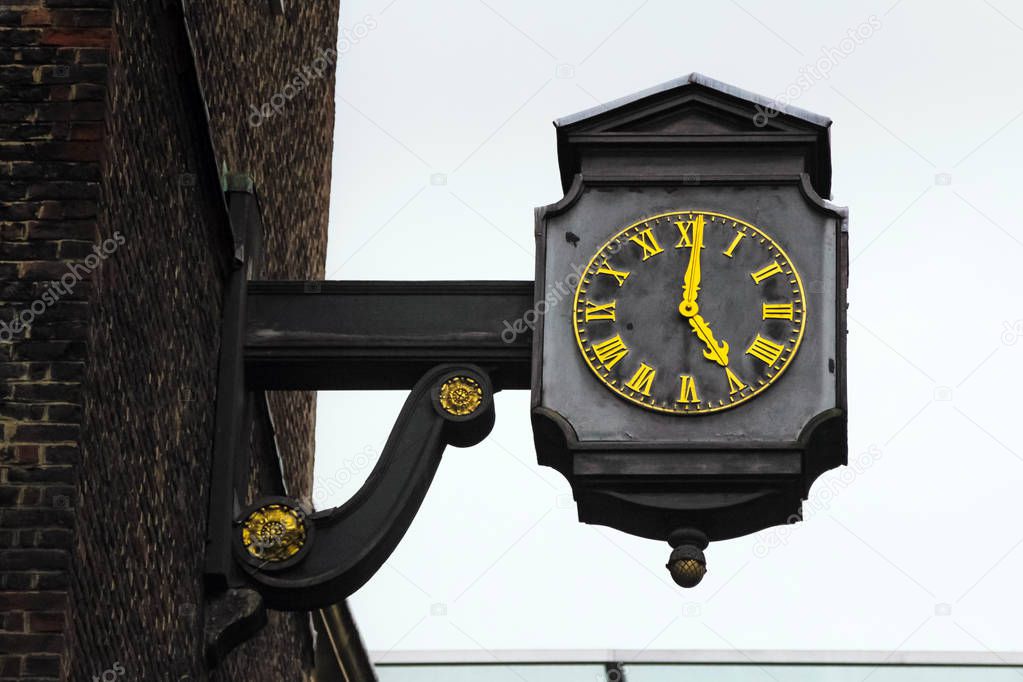 Close up vintage clock in street of London, England showing 5 o'clock, end of work day