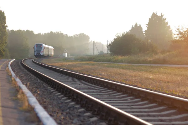 列車は霧の朝に駅を出る 鉄道駅 カラフルな青空 木々や緑の芝生 夏には黄色の太陽の光と産業風景 鉄道の交差点 重工業 — ストック写真