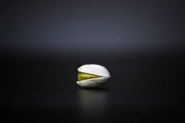 Senin metin için yer karanlık beyaz zemin üzerine tek kavrulmuş gevrek Antep fıstığı