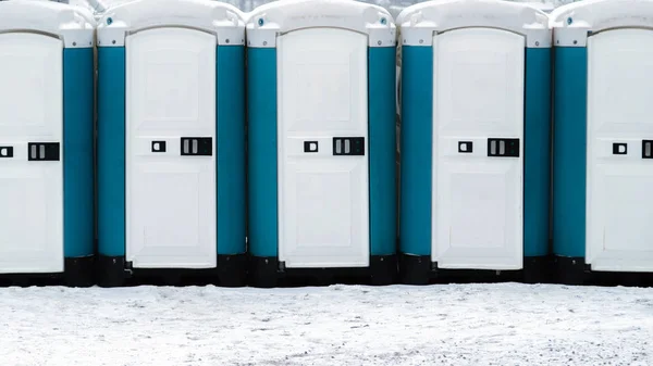 Long row of mobile toilets outside on the snowy ground. Bio toilets outdoors — Stock Image Long Row Mobile Toilets Snowy Ground Bio Toilets Outdoors Stock Image