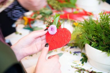 Closeup eller genç kadın çiçekçi çiçek buketi tablo ile kalp şekli oluşturma