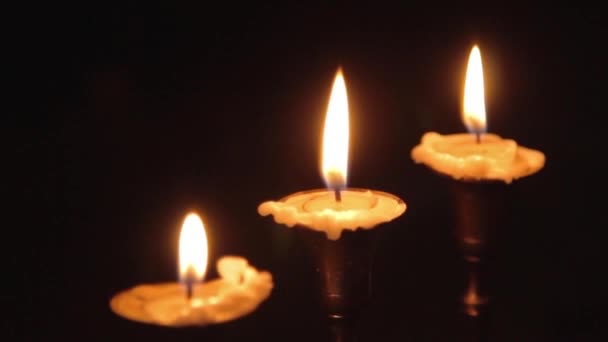 Groupe de bougies maléfiques brûlant dans l'obscurité et copiez l'espace sur un fond en bois avec une clôture en métal sur le côté. Rituel de magie noire ou rite d'Halloween effrayant .