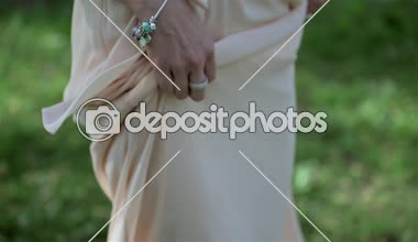 Güzel sarışın kız yere yalınayak iplik ipek elbise giyiyor. Gelin, düğün günü