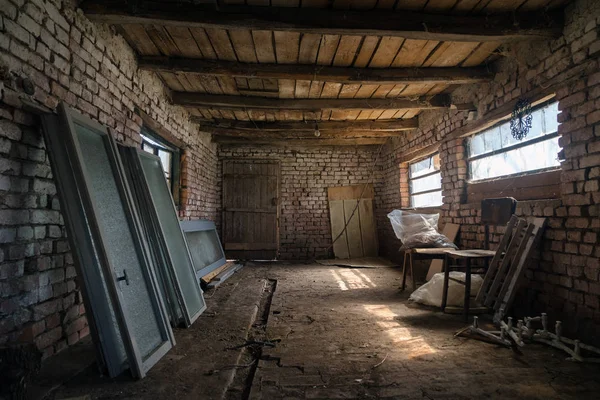 Antiguo granero interior en el pueblo. cobertizo vintage construido en madera y ladrillo, granero abandonado. Dentro de un establo rústico — Foto de Stock