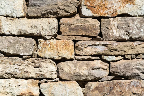 Eski düz kahverengi ve gri taş duvar dokusu kapatın. Bir ev veya bina katmanlı buzlu. Mimari taş duvar dış Bulgaristan'da tipik — Stok fotoğraf