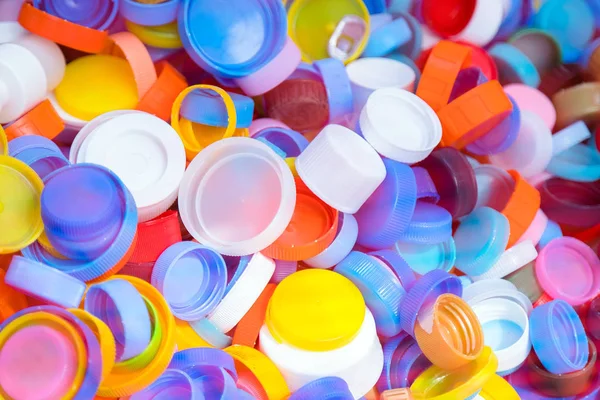 Montón de tapas de botellas de plástico textura. Una gran cantidad de tapas de botellas de refrescos, reciclaje de plástico — Foto de Stock