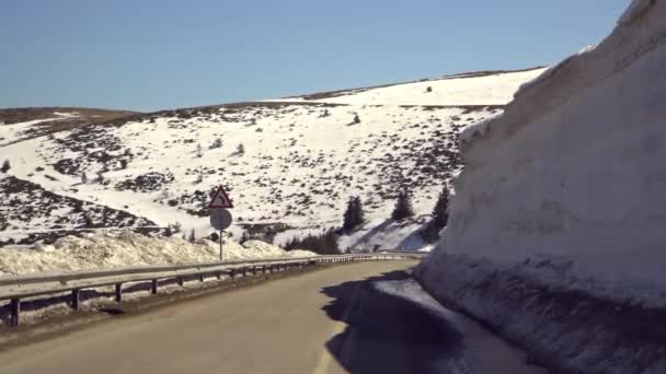 Voiture conduisant sur la route étroite dans le col de Beklemeto, montagnes des Balkans, Bulgarie. Fusion de la neige au printemps, conduite dangereuse 