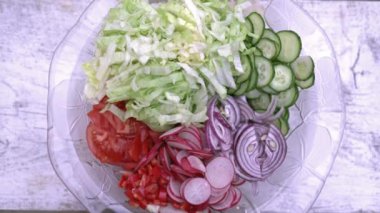 Taze doğranmış yaz salatası. Çok lezzetli sebze cam salata kasesi - salatalık, marul, turp, domates, kırmızı soğan