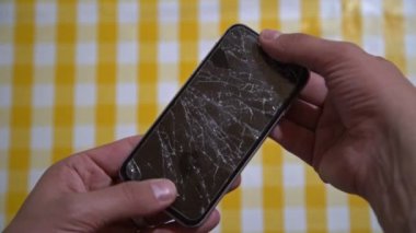 Bozuk ekranlı akıllı telefon kavramı. Adamın ellerinin kırık ekranlı bir telefonu tuttuğu en iyi görüntü. Modern cep telefonunda çatlak, parçalanmış, dokunmatik bir ekran. Gadget 'ın onarılması gerekiyor