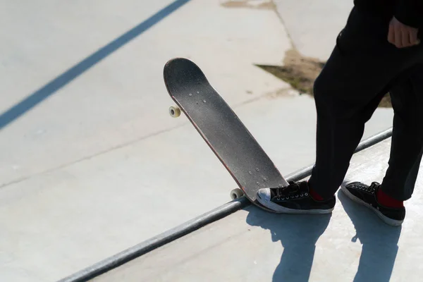 Joven atleta de skate de pie en la rampa preparándose para caer en un monopatín. Practica freestyle, actividad deportiva urbana extrema para jóvenes, manteniéndote alejado de los problemas — Foto de Stock