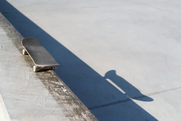 Monopatín profesional tendido sobre repisa de hormigón en skate park. Practica freestyle, actividad deportiva urbana extrema para jóvenes, manteniéndote alejado de los problemas — Foto de Stock