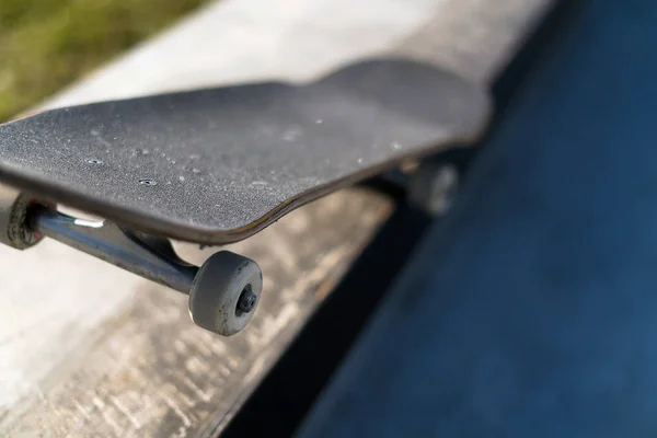 Monopatín profesional tendido sobre repisa de hormigón en skate park. Practica freestyle, actividad deportiva urbana extrema para jóvenes, manteniéndote alejado de los problemas — Foto de Stock