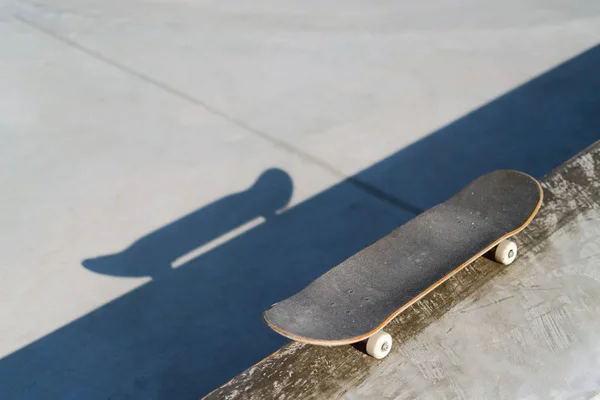 Monopatín profesional tendido sobre repisa de hormigón en skate park. Practica freestyle, actividad deportiva urbana extrema para jóvenes, manteniéndote alejado de los problemas — Foto de Stock