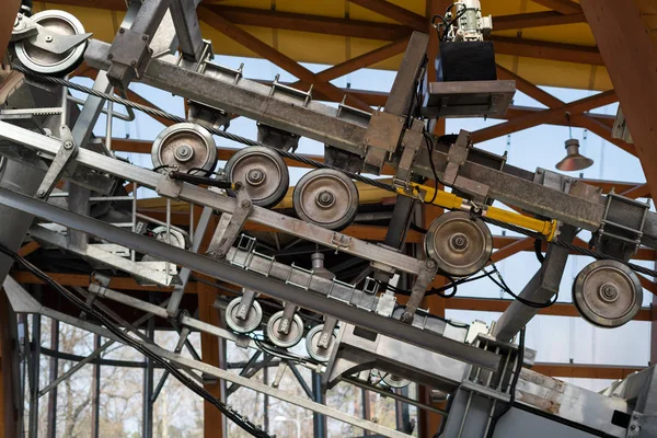 回転車輪が付いている金属のケーブルカーのメカニズム。山にエレベーターを持ち上げる — ストック写真