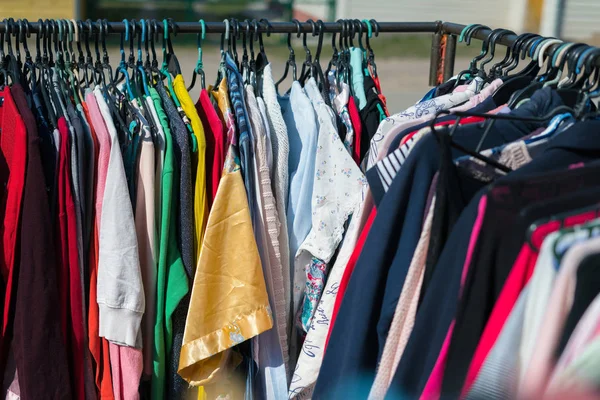 Primer plano de diferentes texturas de ropa colgando en el mercado callejero — Foto de Stock