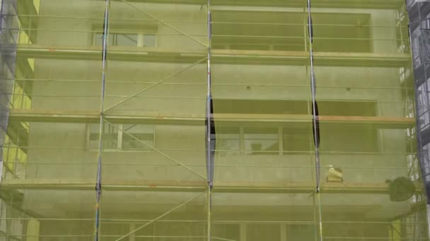Fassadensanierung Altbausanierung Reparatur Gerüst Vor Hausfassade Mit Gelbem Transparenten Stoff — Stockvideo