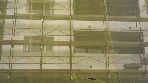 Fassadensanierung Altbausanierung Reparatur Gerüst Vor Hausfassade Mit Gelbem Transparenten Stoff — Stockvideo