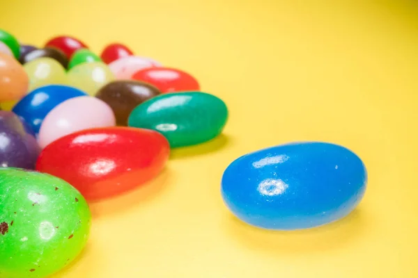 Mucchio di deliziose caramelle colorate da masticare sfondo. Dolci colorati su sfondo giallo — Foto Stock