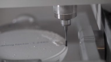 Profesyonel CNC diş değirmeni makinesi. Diş laboratuarında yapay diş şekilleri oyuyor. Klinikteki diş teknisyenleri tarafından yapılan yapay dişlerden biri.