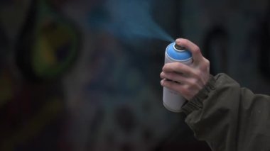 Duvara boyama dan önce sprey boya çalışıyor sokakta Grafiti sanatçısı. Özel mülkiyete zarar, şablon sokak sanatı, kent kültürü
