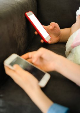 Genç kızlar elinde boş bir ekran ile akıllı telefon tutarken ve iletişim değilken bir kanepeüzerinde yatıyordu. Genç kızlar sosyal medyada kaydırma kullanarak, gençlik bağımlılığı
