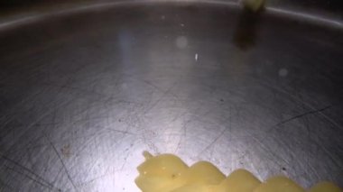 Kıvrılmış İtalyan makarnasının su altı fotoğrafı kaynar suya düştü. Metal tencerede pişirme aptal taneli makarna